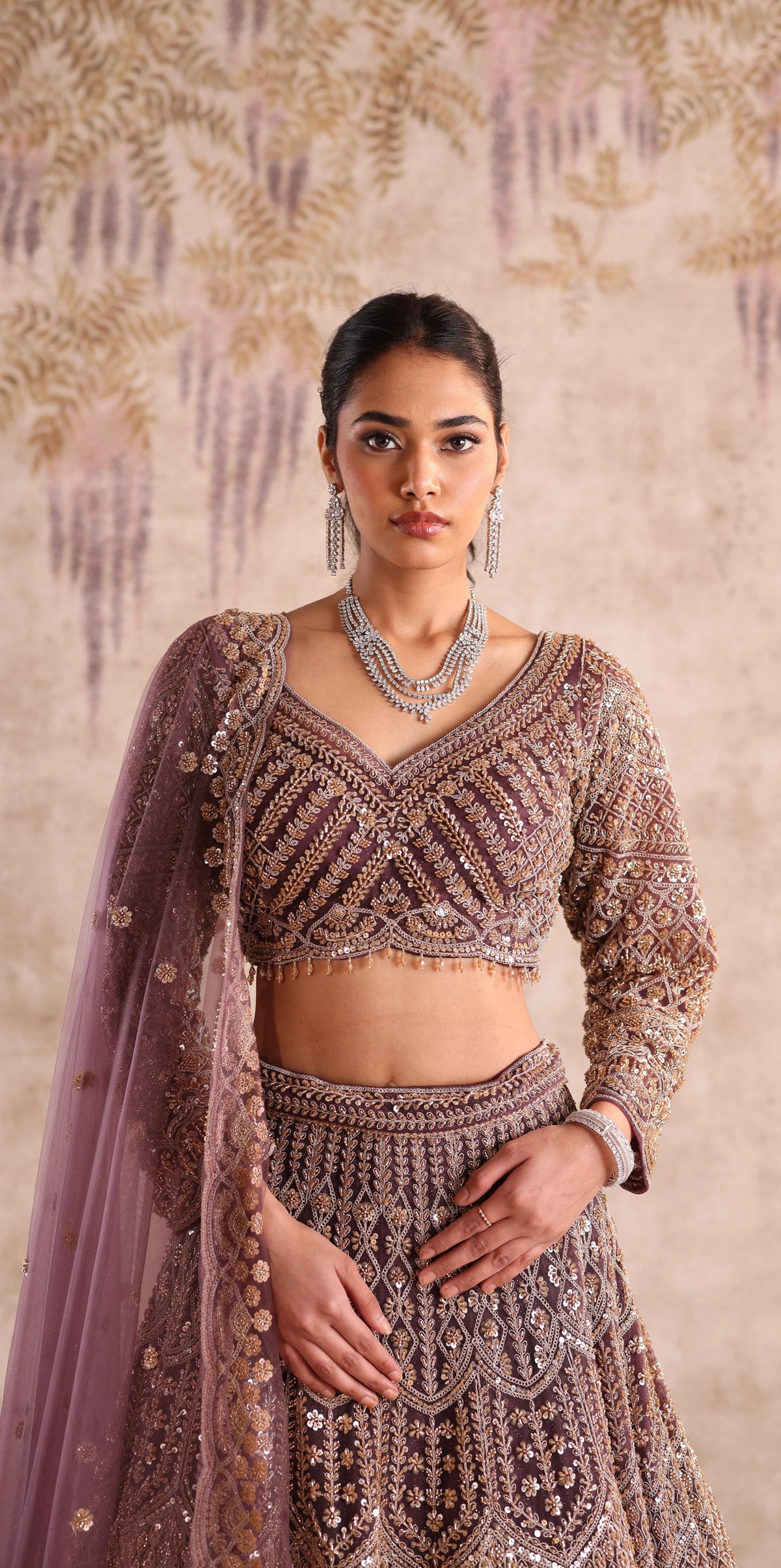 Woman wearing a traditional embroidered outfit with a beige background