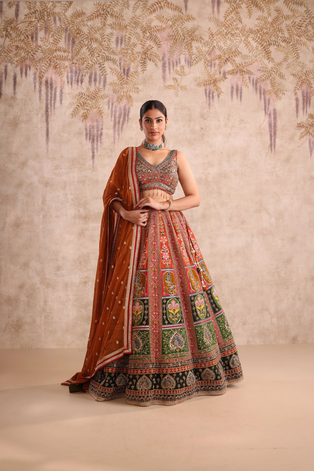 Woman in a traditional embroidered lehenga with a decorative background