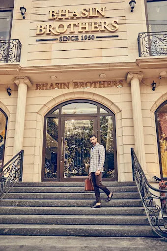 Man walking up the steps of a building with 'Bhasin Brothers' signage.