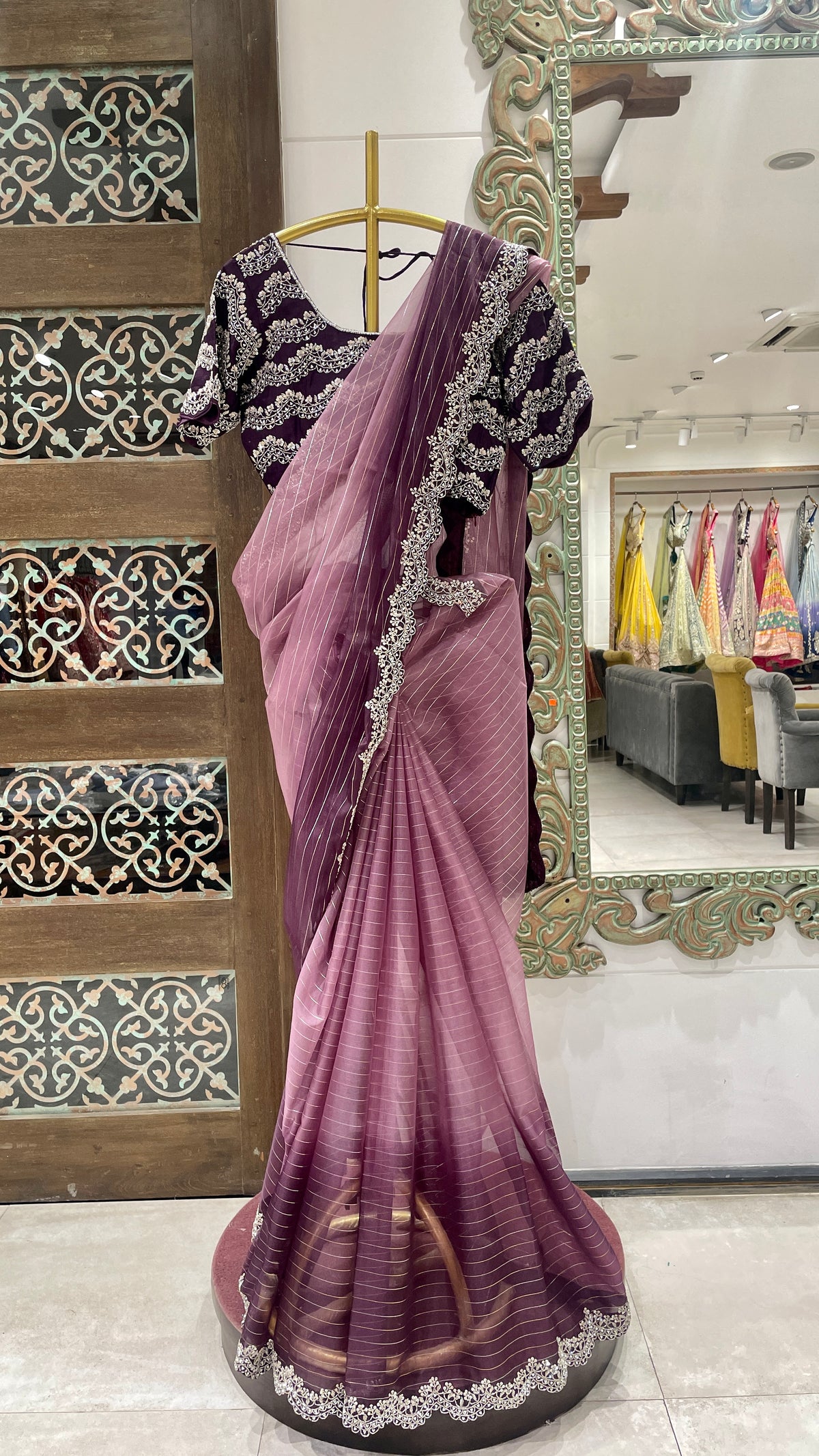 A purple ombre organza saree with embellishments displayed on a mannequin, with intricate border and pallu details.